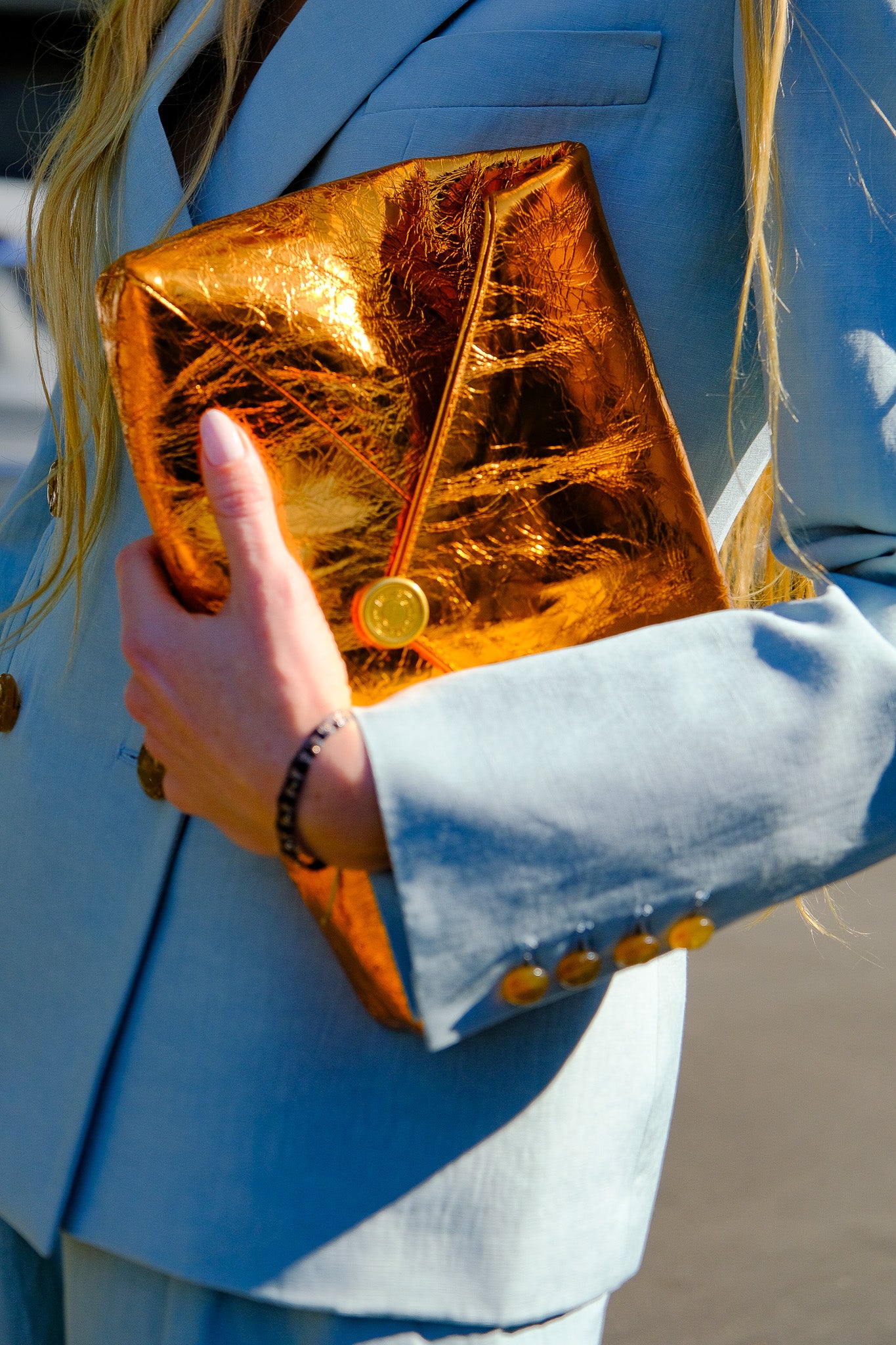 Crinkled copper envelope clutch in leather with a gold magnetic closure and detachable chain strap. Available in Charlotte, NC and Brentwood, CA.