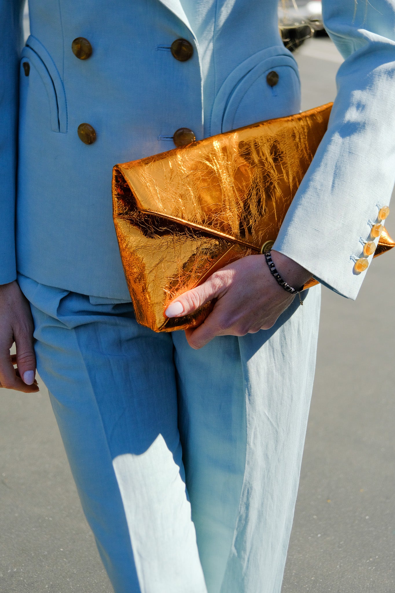 Crinkled copper envelope clutch in leather with a gold magnetic closure and detachable chain strap. Available in Charlotte, NC and Brentwood, CA.