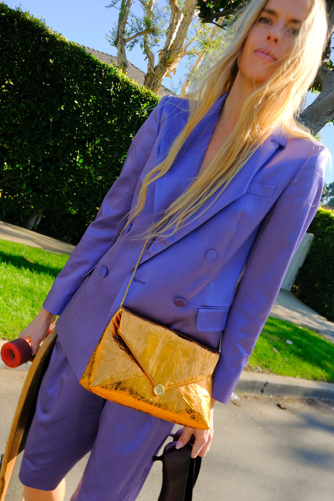 Crinkled copper envelope clutch in leather with a gold magnetic closure and detachable chain strap. Available in Charlotte, NC and Brentwood, CA.