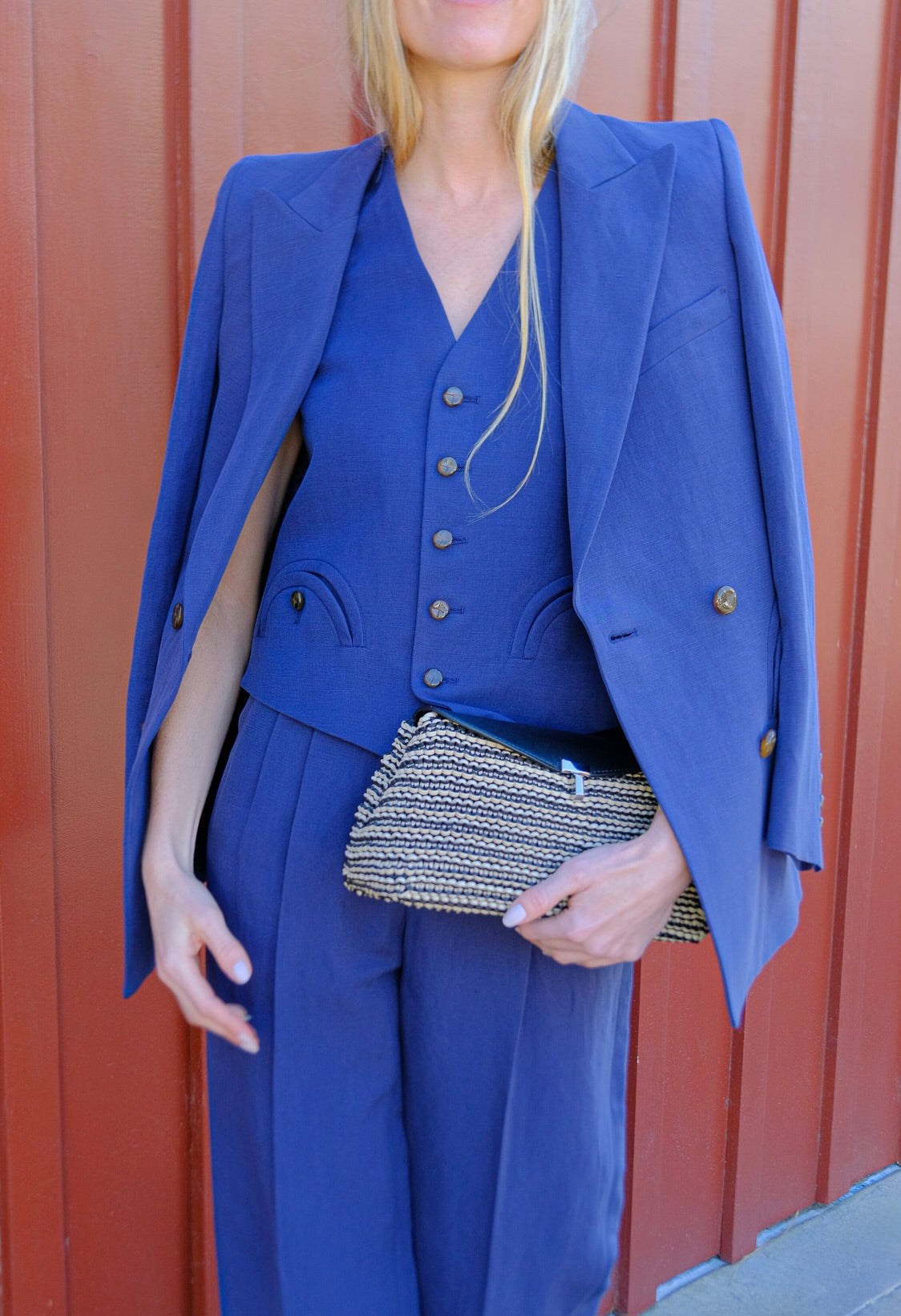 Black and sand woven leather clutch from Totême with a T-lock closure and refined minimal silhouette. Available in Brentwood, CA and Charlotte, NC.