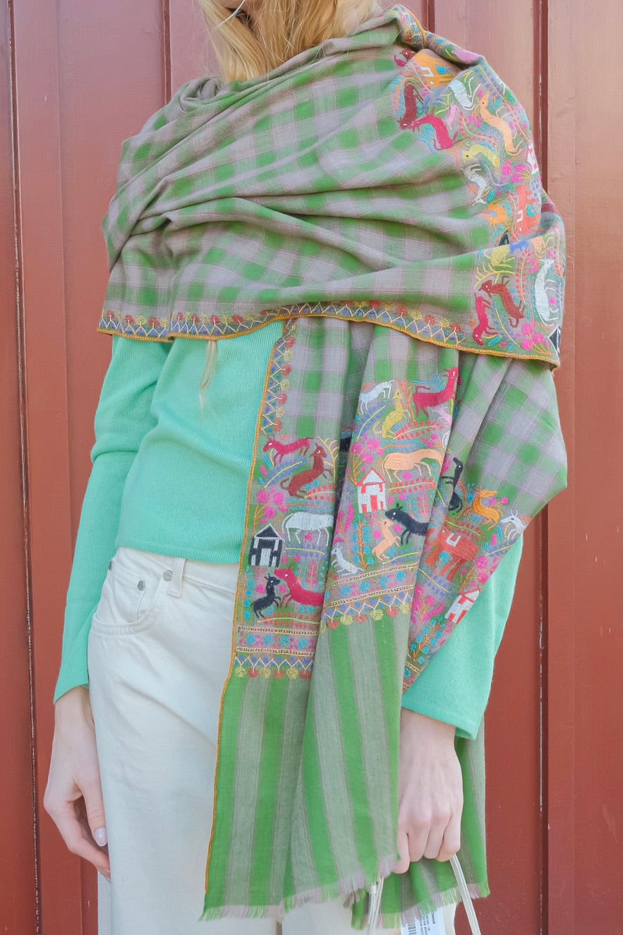 Yaser Shaw animal print shawl on green plaid background. Available in Brentwood, CA and Charlotte, NC.